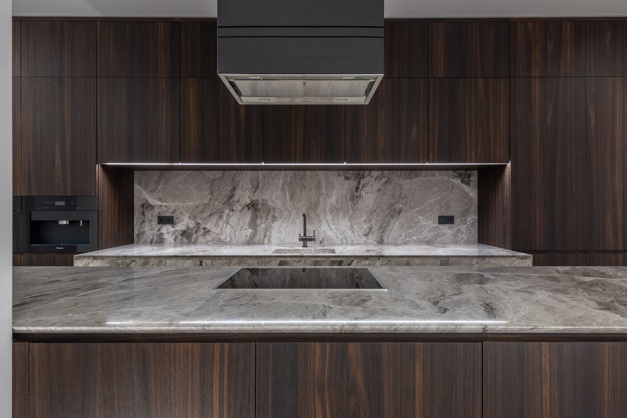 creative-03 Sleek modern kitchen interior featuring marble countertops and dark wood cabinets.